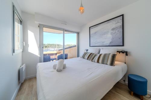Schlafzimmer mit einem großen weißen Bett und einem großen Fenster in der Unterkunft Atlantic Selection - Le Catamaran - Face au port in Capbreton
