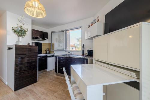 une cuisine avec une table blanche et une grande fenêtre dans l'établissement Atlantic Selection - Le Catamaran - Face au port, à Capbreton