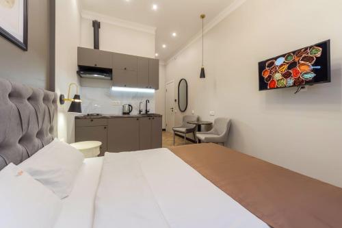 a bedroom with a white bed and a kitchen at Apartments on Antonovycha in Kyiv