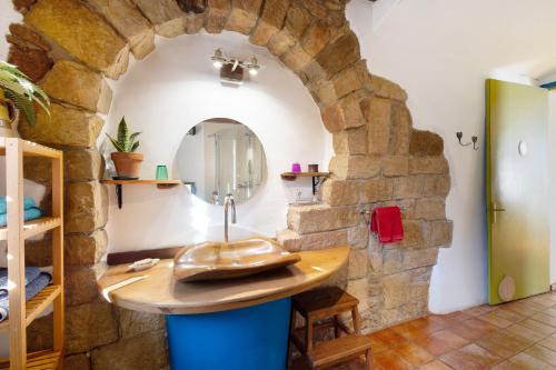 La salle de bains est pourvue d'un lavabo et d'un mur en pierre. dans l'établissement Cal Malla petit, à Artés