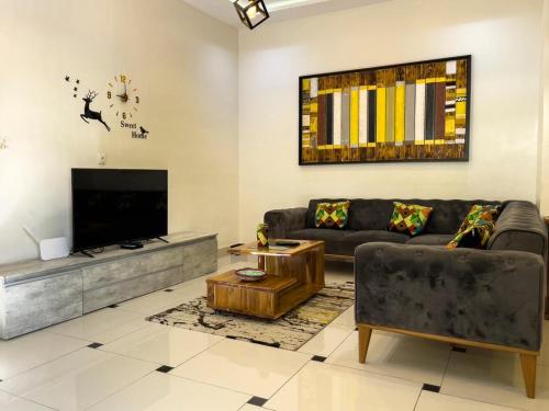 a living room with a couch and a flat screen tv at Villa deux chambres in Cotonou