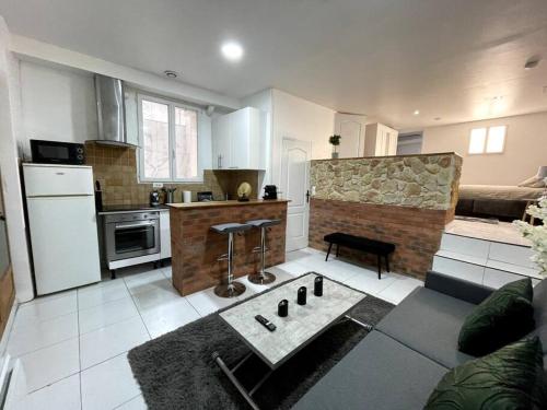 un salon avec une cuisine et une table dans l'établissement Loft cosy et très élégant, à Saint-Cyr-lʼÉcole