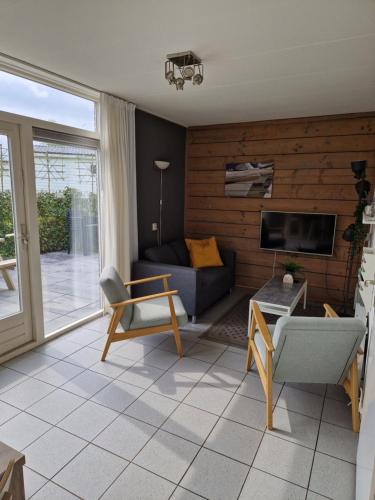 a living room with a couch and a tv at De Rakken in Woudsend