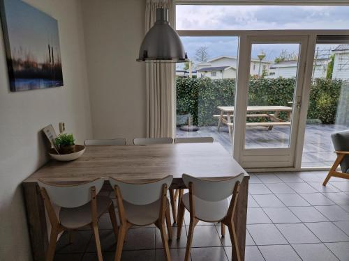 een eetkamer met een houten tafel en stoelen bij De Rakken in Woudsend