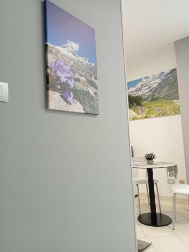a room with a table and a picture on the wall at Il Mughetto in Aosta