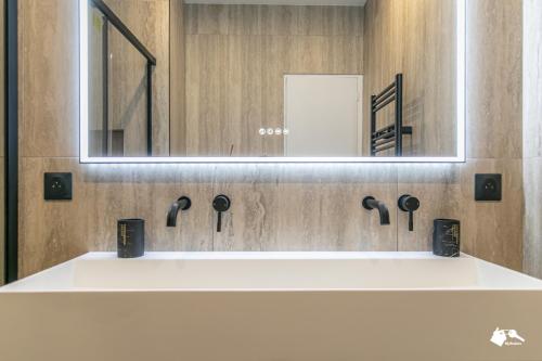 une salle de bain avec un lavabo blanc et un miroir dans l'établissement MBA - Felix Faure Luxury Appart proche Tour Eiffel, à Paris
