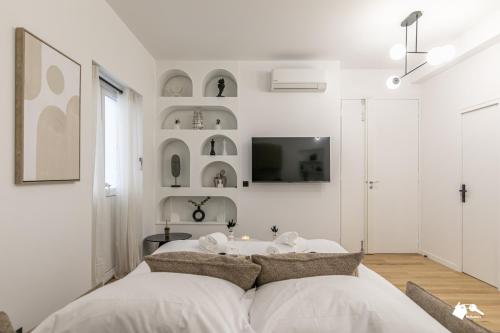 - une chambre avec des murs blancs et un lit avec des oreillers dans l'établissement MBA - Felix Faure Luxury Appart proche Tour Eiffel, à Paris