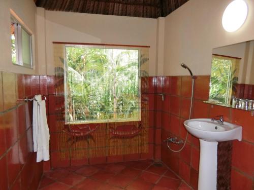 a bathroom with a sink and a window at Thuy - Gunter Garden Bungalow in Mui Ne