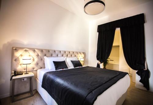 um quarto com uma cama grande e um cobertor preto em Chic & Town Luxury Rooms em Roma