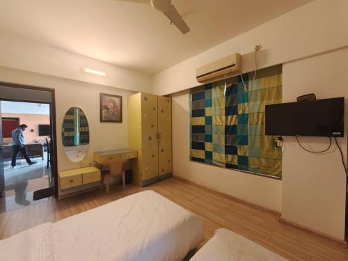 a bedroom with a bed and a desk and a mirror at Quality Hospitality Services in Pune