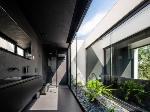 a bathroom with a sink and a window and plants at Hotel Pepe Vieira in Raxo