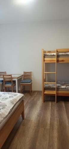 1 Schlafzimmer mit 2 Etagenbetten und einem Tisch in der Unterkunft Vinný sklep s apartmány u Kvěchů in Bavory