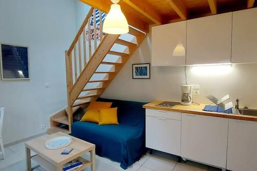 Cette chambre dispose d'un lit bleu et d'un escalier. dans l'établissement Maisonnette LA CORDE avec terrasse privée, à Granville