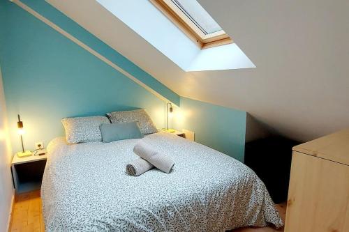 une chambre avec un grand lit avec une lucarne dans l'établissement Maisonnette LA CORDE avec terrasse privée, à Granville