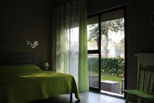 1 dormitorio con cama verde y ventana grande en Casa EUROPA, en Cavallino-Treporti