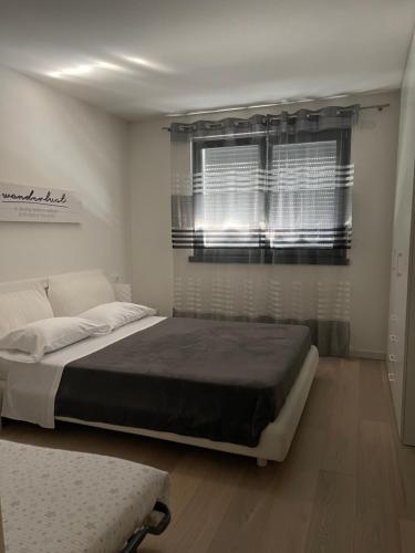 een slaapkamer met een groot bed en een raam bij Riva House in Riva del Garda