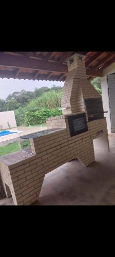 a model of a brick fireplace in a yard at Chácara cantinho da paz in Quadra