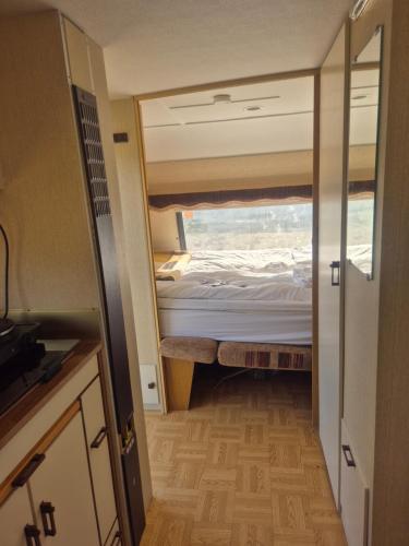 ein kleines Schlafzimmer mit einem Bett in einem winzigen Haus in der Unterkunft Vintage caravan in Synes
