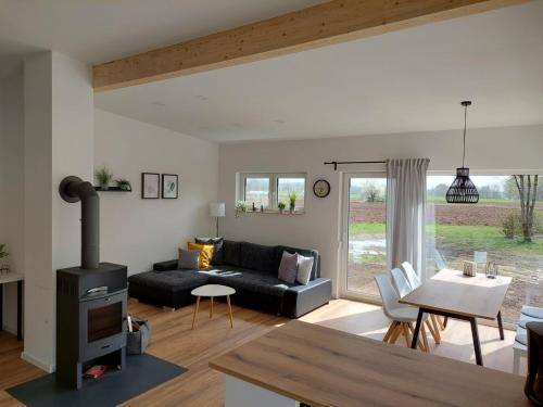 sala de estar con sofá negro y mesa en Ferienhaus Casa Neugrua en Stockheim