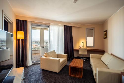 a hotel room with a couch and a chair and a table at Delta Hotels by Marriott Olbia Sardinia in Olbia