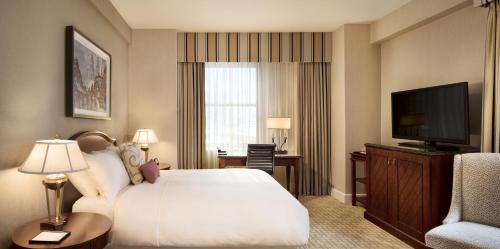a hotel room with a bed and a television at Fairmont Royal York Hotel in Toronto