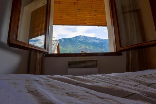 - une chambre avec une fenêtre offrant une vue sur la montagne dans l'établissement Appartement au cœur de l'Oisans, au Bourg-dʼOisans
