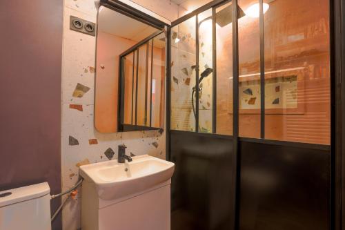 une salle de bain avec un lavabo et un miroir dans l'établissement Appartement au cœur de l'Oisans, au Bourg-dʼOisans