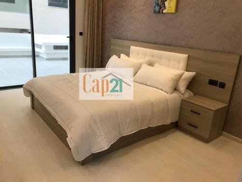 een bed met een wit dekbed en kussens erop bij apartment safir 2 (families) in Tanger