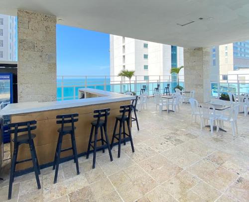 a bar on the top of a building with chairs and tables at Hotel Cartagena Premium in Cartagena de Indias