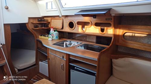 una pequeña cocina con fregadero y fregadero en Jacht motorowy Calipso 750, en Ryn