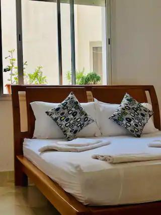 uma cama com almofadas num quarto com janelas em Appartement Pied Dans L'eau ! em Beni Khiar