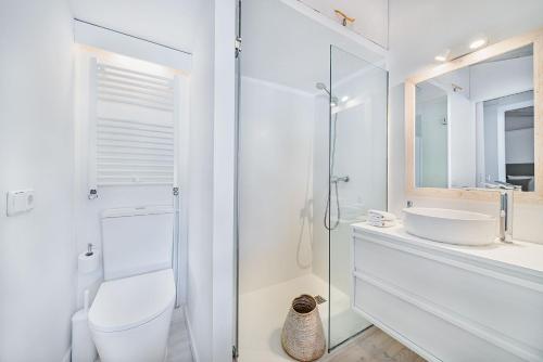 a white bathroom with a toilet and a sink at Casa Blanca in El Port de la Selva