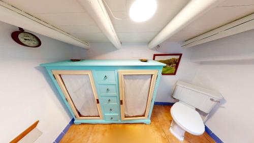 ein Badezimmer mit einem blauen Schrank und einem WC in der Unterkunft La Apañaora in Galaroza