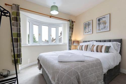 a bedroom with a large bed and a window at Beautiful & comfortable home in Stockton-on-Tees