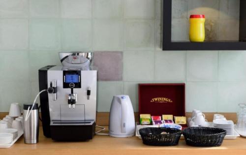 a kitchen counter with a coffee maker and some dishes at Sky apartments FREE PARKING in Wrocław