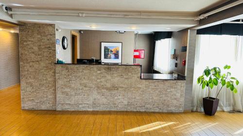 a lobby with a brick wall and a potted plant at Roosevelt Hotel in Williston