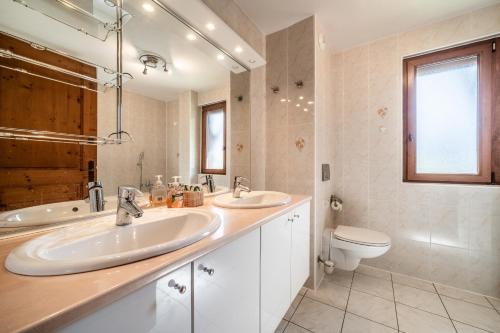 La salle de bains est pourvue de 2 lavabos et de toilettes. dans l'établissement Le Criou, à Samoëns