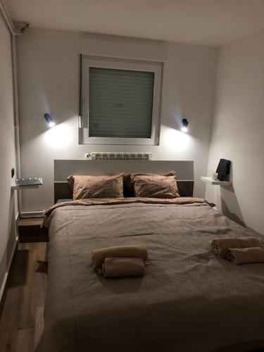 a bedroom with a large bed with two pillows on it at Blue apartman in Belgrade