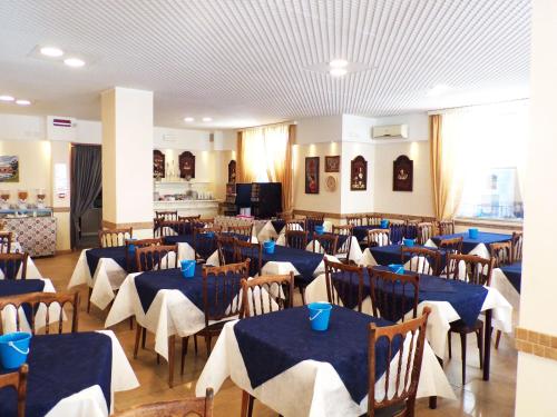 uma sala de jantar com mesas e cadeiras com guardanapos azuis em Hotel Graziella Mare em Rimini