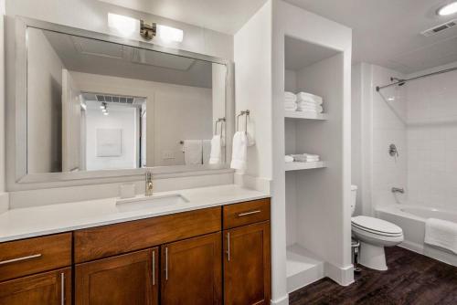 a bathroom with a sink and a toilet and a mirror at Landing at City North - 1 Bedroom in Valley Ranch in Irving