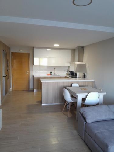 a kitchen and living room with a couch and a table at Apartamentos Mar y Playa in Moaña