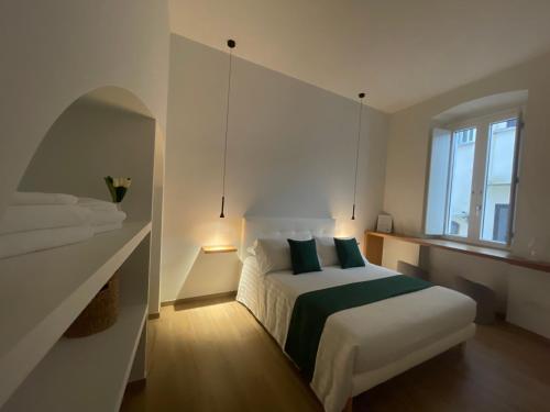 a white bedroom with a bed and a window at Blanco B&B - Group in Trani