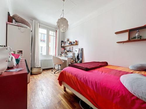 Schlafzimmer mit einem roten Bett und einem Schreibtisch in der Unterkunft Charmante maison près des Puces in Saint-Ouen