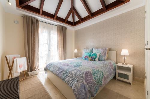 ein Schlafzimmer mit einem Bett und einem großen Fenster in der Unterkunft Beautiful Flat with heated pool near the beach in Arguineguín