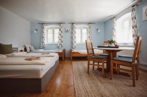 sypialnia z 2 łóżkami, stołem i krzesłami w obiekcie Pokój i Spokój Agroturystyka w mieście Zacisze