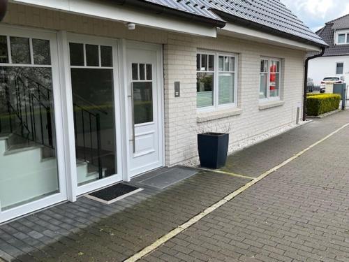 une maison avec sa porte ouverte et une poubelle à l'extérieur dans l'établissement Familienzeit, moderne Ferienwohnung mit Sauna in Timmendorfer Strand, à Timmendorfer Strand