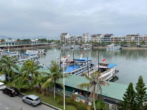 a group of boats docked in a river with buildings at Bảo An Hotel- Tuần Châu Hạ Long in Ha Long
