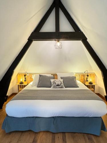 - une chambre avec un grand lit avec un chien dans l'établissement Gites - Domaine de Geffosse, à Pont-l'Évêque