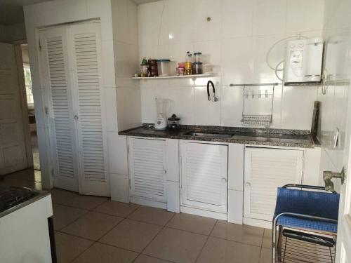 cocina con armarios blancos y encimera en Casa 4 quartos, 2 suítes c/ acessibilidade en São Pedro da Aldeia