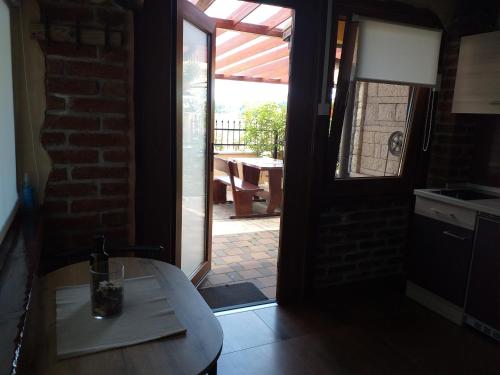 eine Küche mit Tisch und Tür zu einer Terrasse in der Unterkunft Monte studio app 1 in Umag